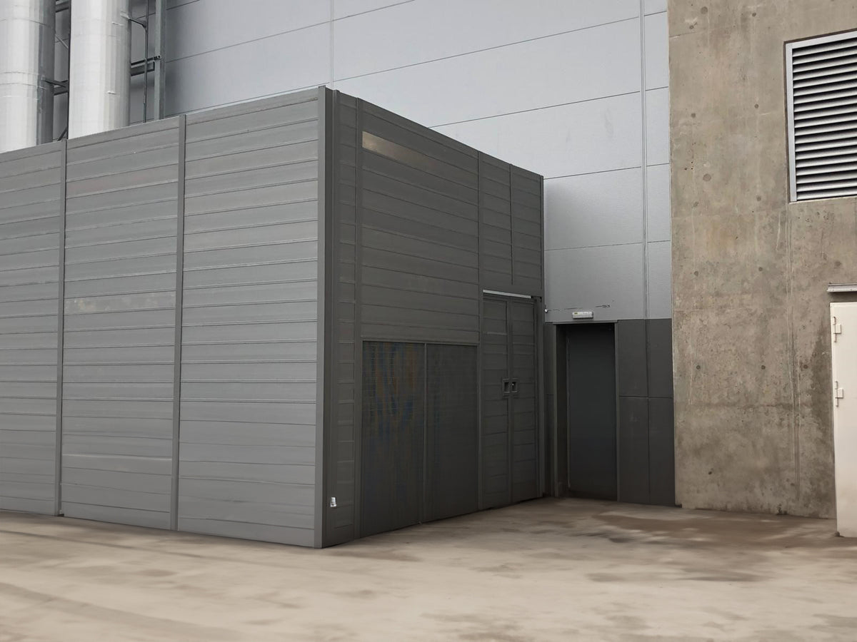 Modular recycled noise barrier design installed in an industrial area