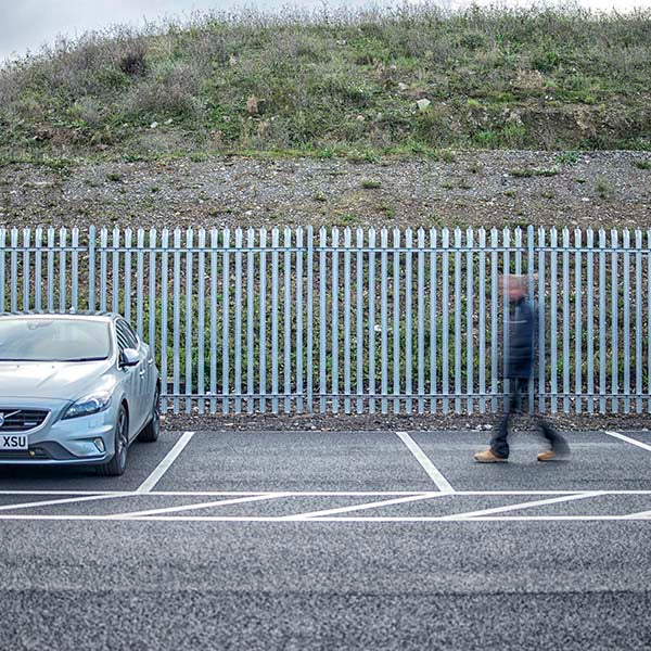 Palisade fencing with car and man 